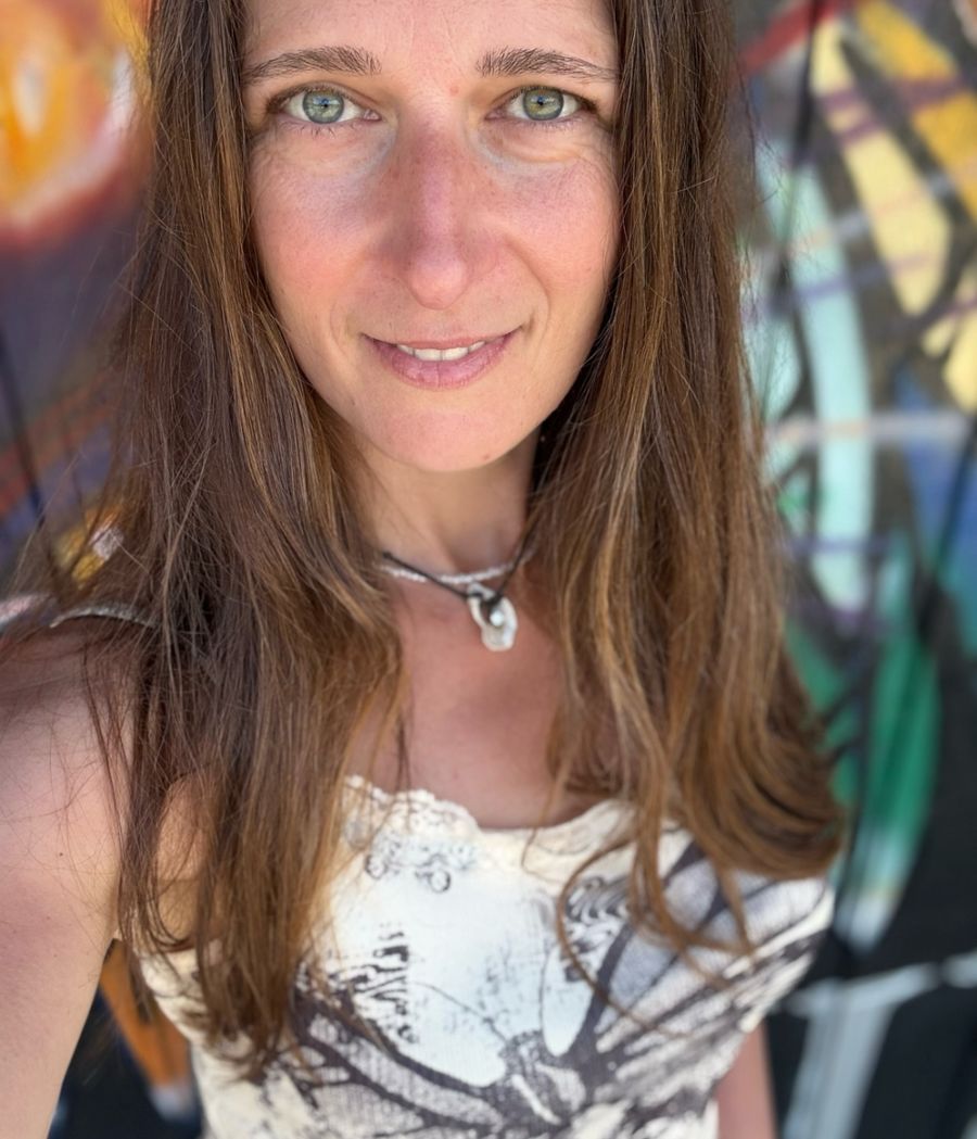 Monika Kulaga smiling in front of a colourful mural